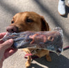JR Pet Products Beef Snout dog treat being sniffed by a large brown dog.